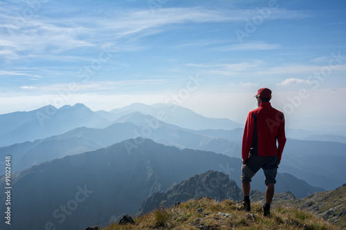 Hiker looking over the mountain ridges © catgrig