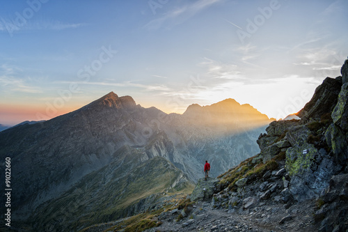 Hiker looking over a beatiful valley in the sunset photo