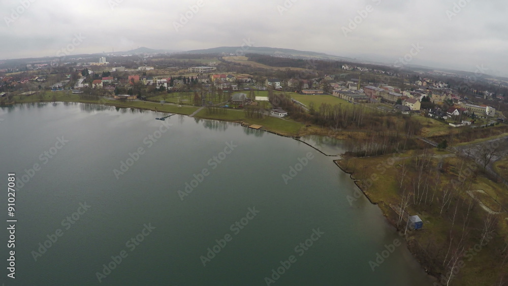Aerial shot of small town near lake, top view of rural area, autumn landscape Aerial shot of small town near lake, top view of rural area, autumn landscape