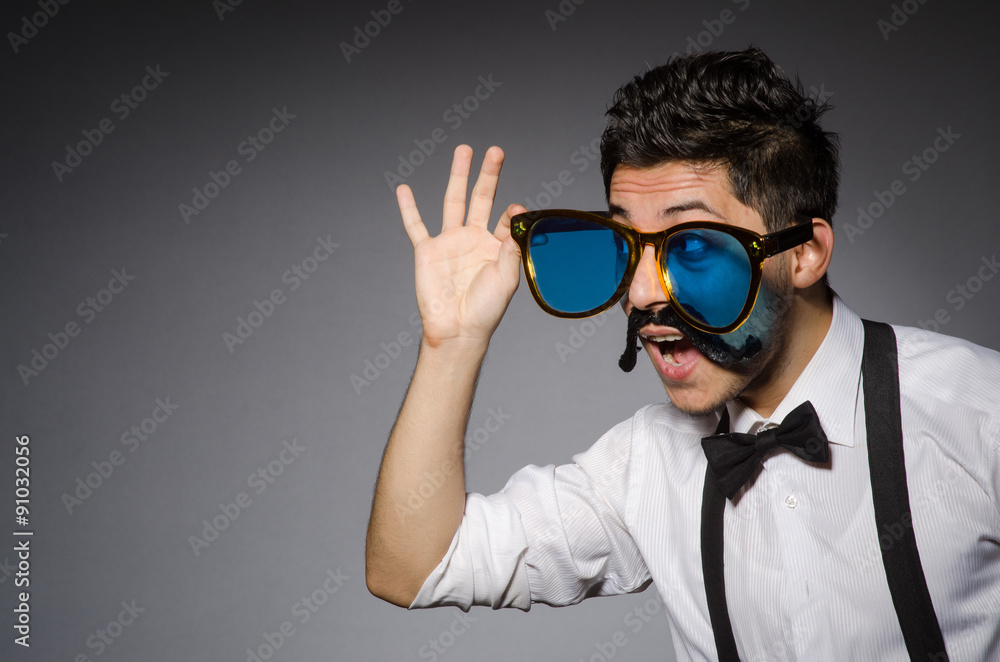 Young caucasian man wearing sunglasses against gray Young caucasian man wearing sunglasses against gray