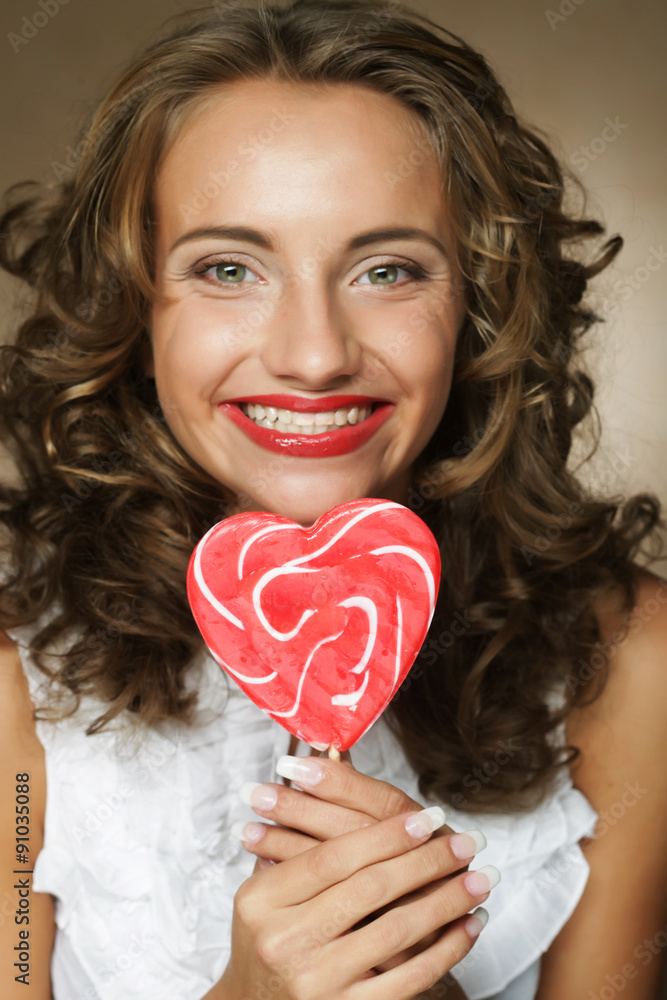 pretty curly girl with a lollipop in her hand pretty curly girl with a lollipop in her hand