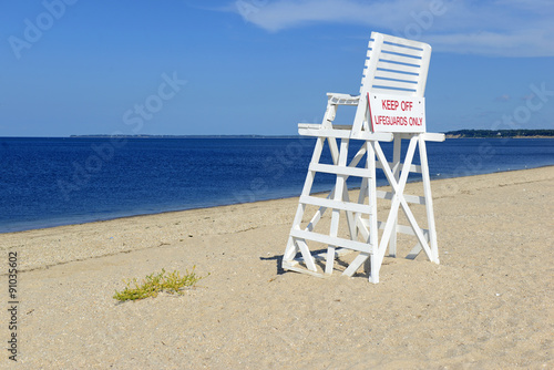 Fototapeta Naklejka Na Ścianę i Meble -  White lifeguard chair on empty sand beach with blue sky