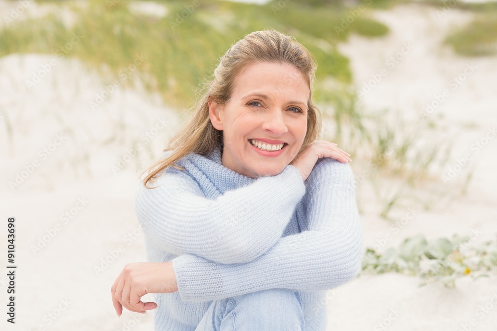 Smiling woman sitting on the sand Smiling woman sitting on the sand