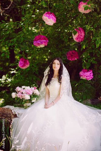 Happy young bride in a pink zone decorated with peonies in nature, family, relationships, romance, smiles, hugs, love, lifestyle