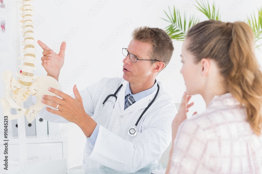 Doctor explaining anatomical spine to his patient Doctor explaining anatomical spine to his patient