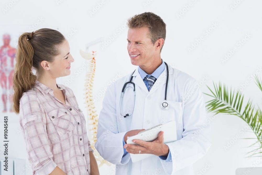 Happy doctor with clipboard talking to patient Happy doctor with clipboard talking to patient