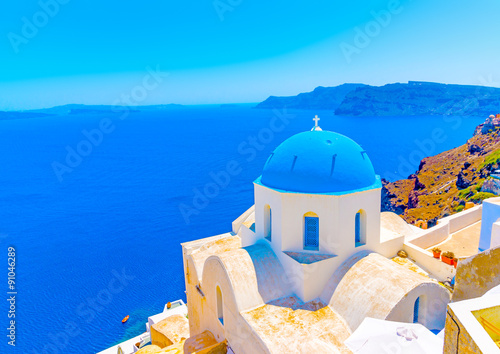 Traditional old church with blue colored dome in Oia the most beautiful village of Santorini island in Greece
