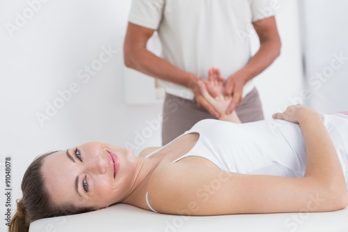 Physiotherapist doing hand massage to his smiling patient
