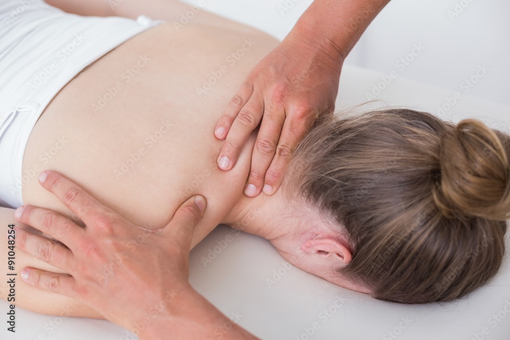 Physiotherapist doing neck massage to his patient Physiotherapist doing neck massage to his patient