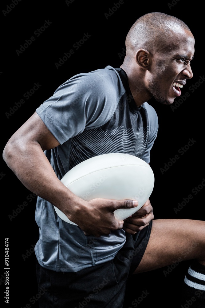 Aggressive sportsman with ball while playing rugby Aggressive sportsman with ball while playing rugby