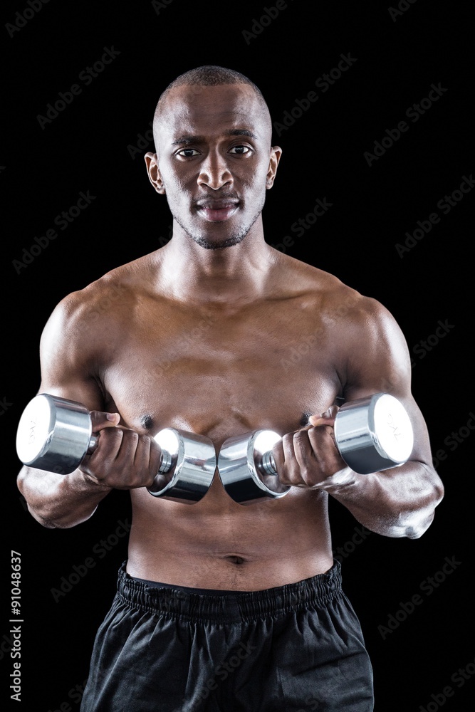 Portrait of confident athlete holding dumbbell