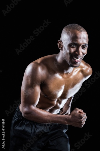 Muscular man smiling while running