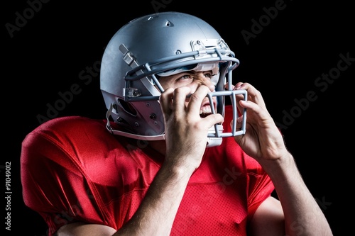 Aggressive American football player holding helmet © WavebreakmediaMicro