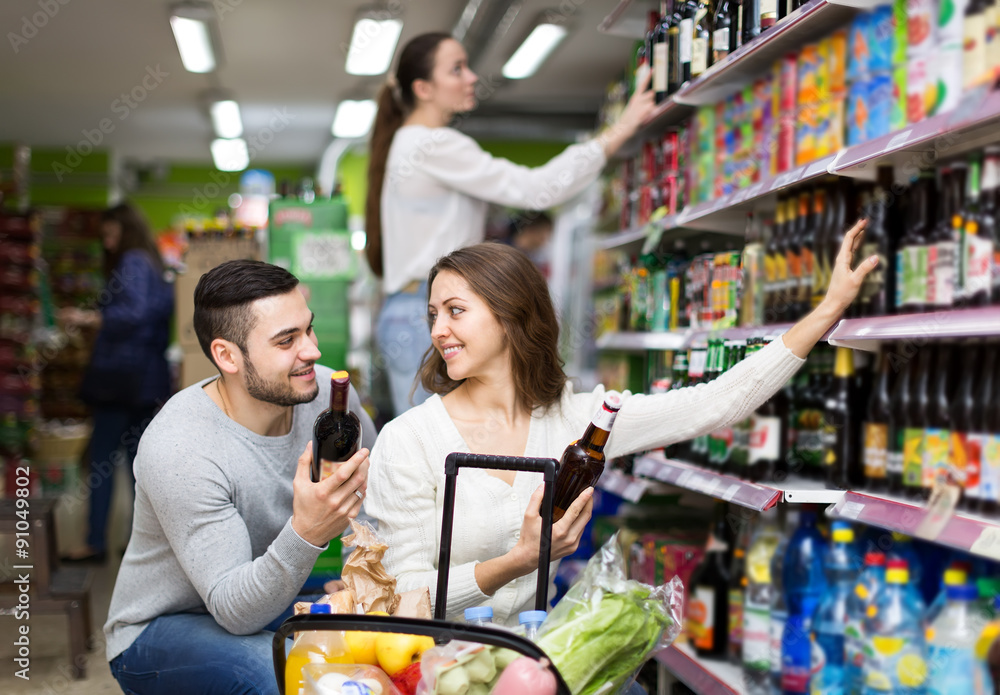 Couple choosing alcoholic beverages in shop