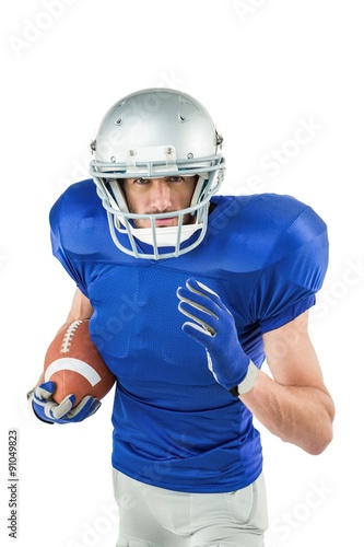 Portrait of American football player running with ball