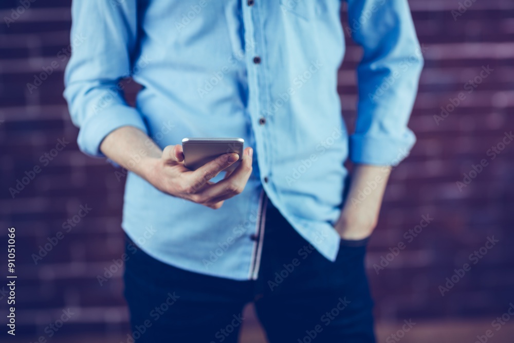 Midsection of man holding smartphone Midsection of man holding smartphone