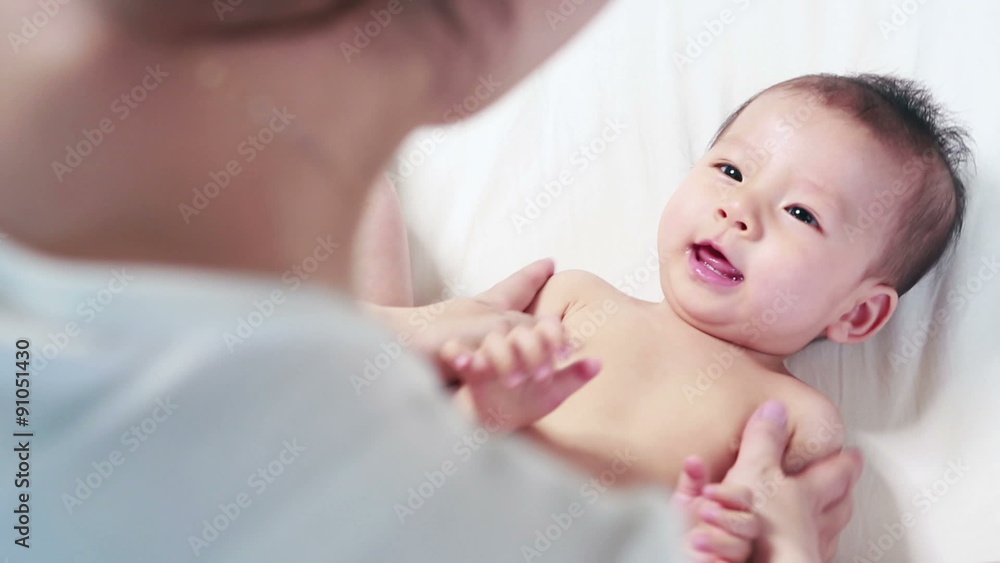 Mother is massaging her baby, Mother creaming cute infant body
