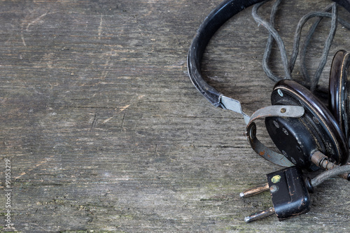 Old music accessories. Headphones on a rustic background.