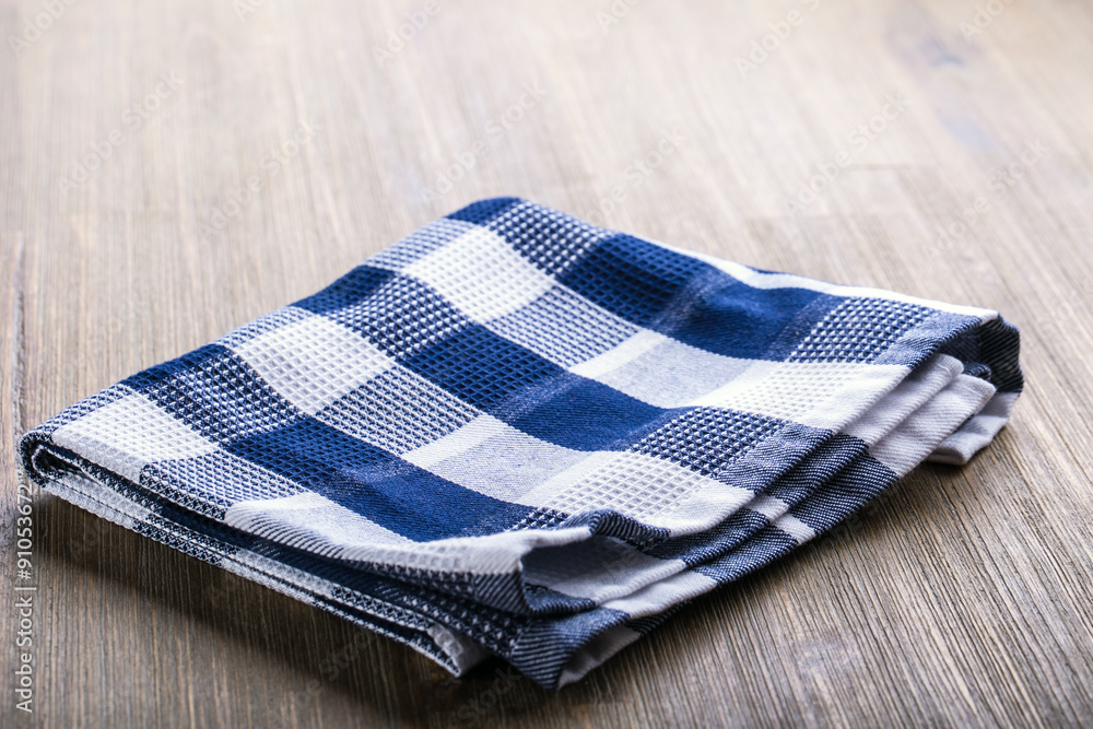 Canvas checkered cloth loosely laid on a wooden table Canvas checkered cloth loosely laid on a wooden table