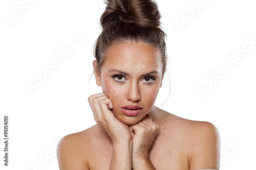 young woman with a light bun posing on a white background photo