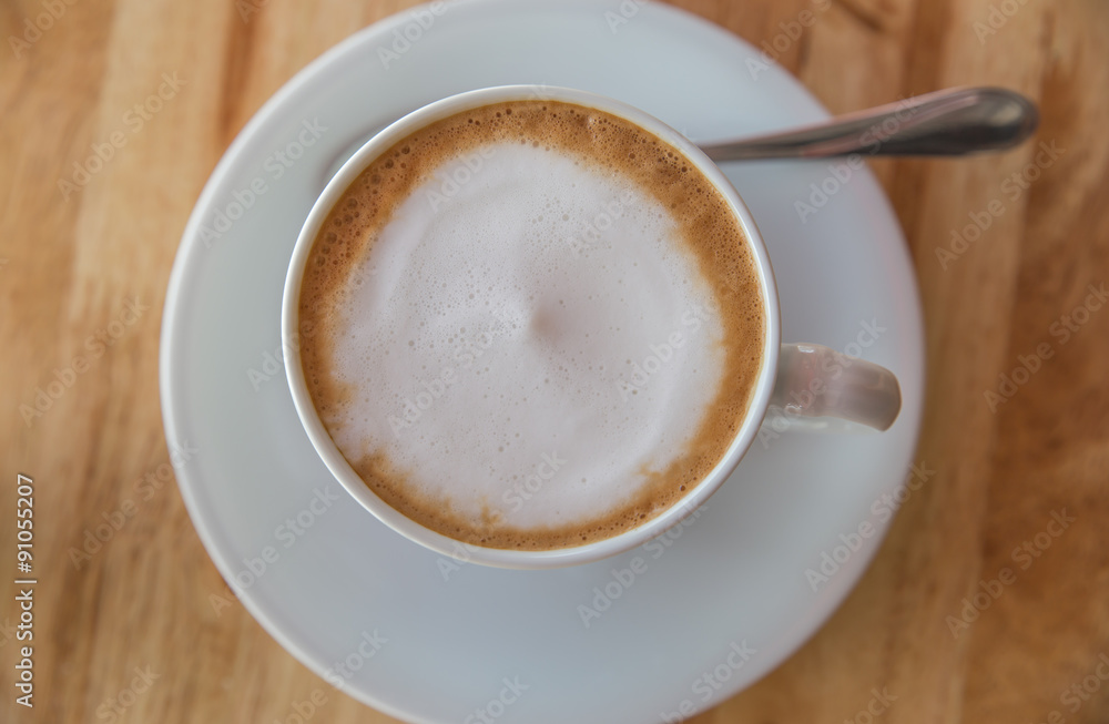 A cup of coffee with in a white cup on wooden background A cup of coffee with in a white cup on wooden background