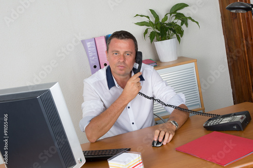 Manager man at his desk at work photo