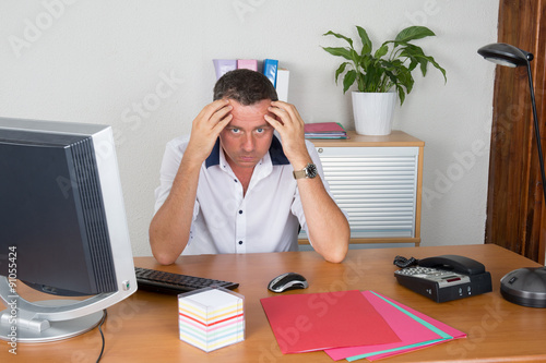 Manager man at his desk at work photo