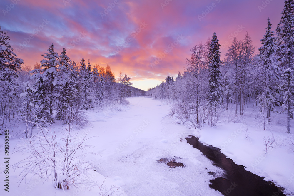 Obraz premium Sunrise over a river in winter near Levi, Finnish Lapland