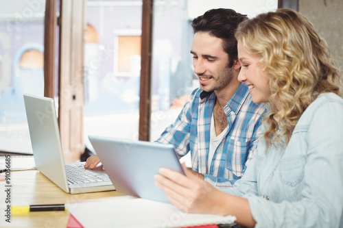 Man showing laptop to woman