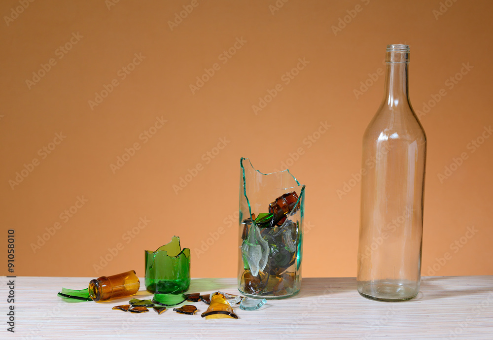 Broken glass and recycled glass bottle on a table StockFoto Adobe Stock