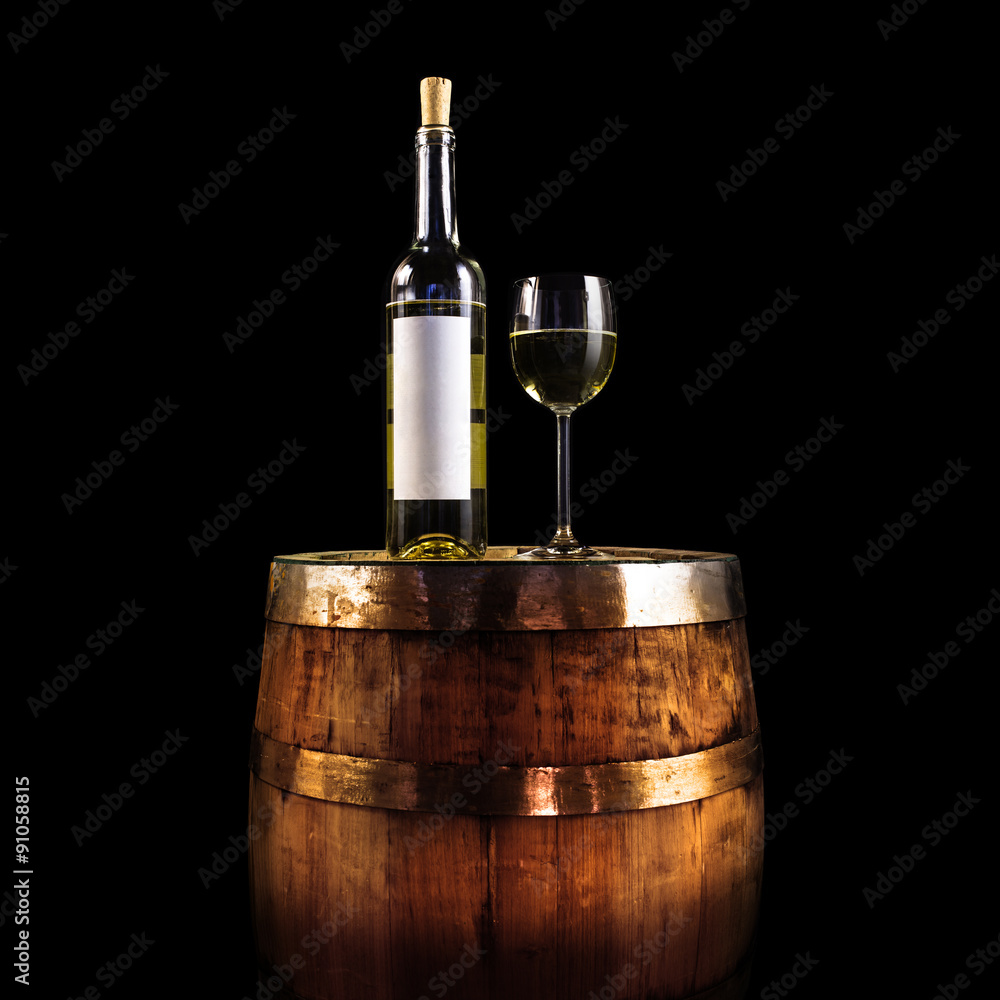 White wine bottle and glass on a wooden barrel - isolated on black 
