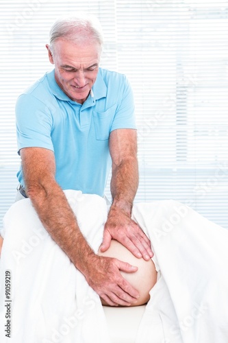 Therapist smiling while massaging belly of pregnant woman