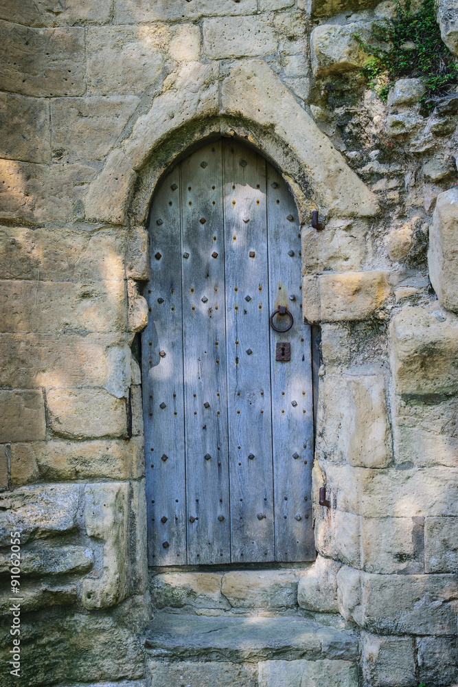 Ancient wooden door in old stone castle wall, Knaresborough, North Yorkshire, UK