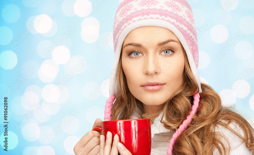 happy young woman in winter hat with cup