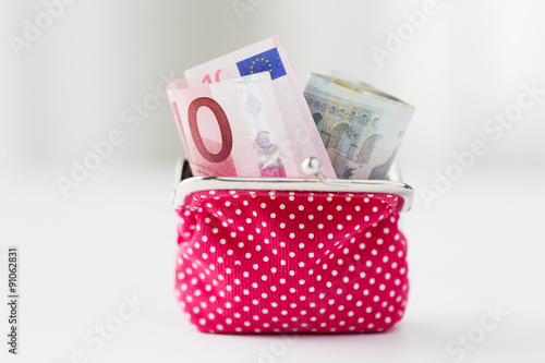 close up of euro paper money in pink wallet