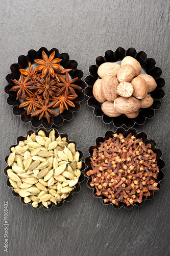 Spices on a black background. Top view, vertical