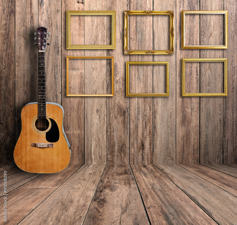 Obraz premium Guitar and picture frame in vintage wood room.