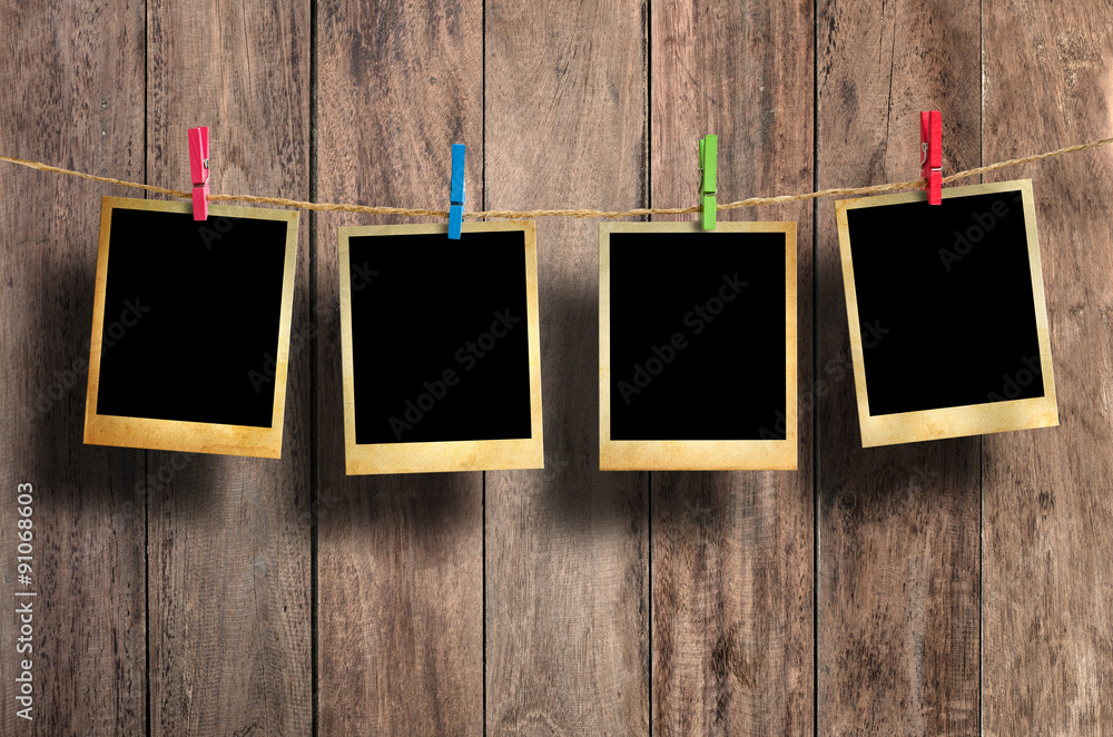 Old picture frame hanging on clothesline on wood background. Old picture frame hanging on clothesline on wood background.