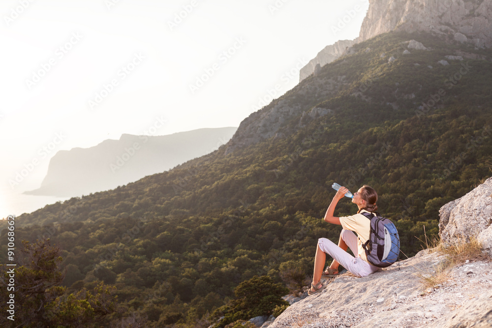 Woman drinks water on the mountain