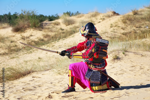 Samurai with sword on the sand. Men in samurai armour on the san