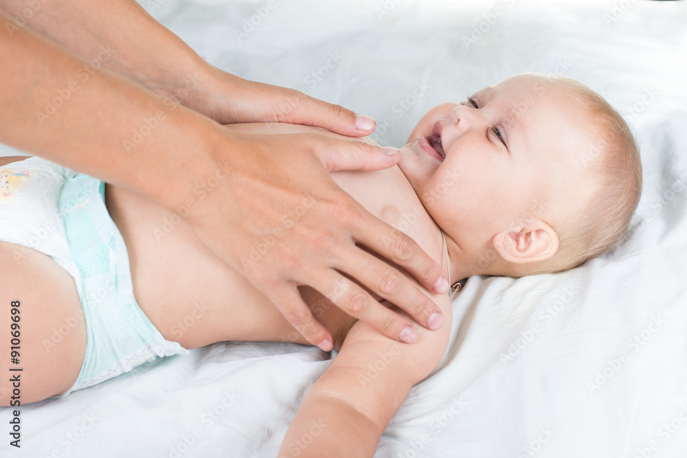 Baby massage. Mother massaging infant belly Baby massage. Mother massaging infant belly