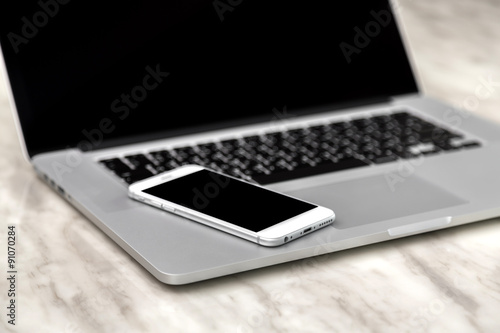 laptop with smart phone on table