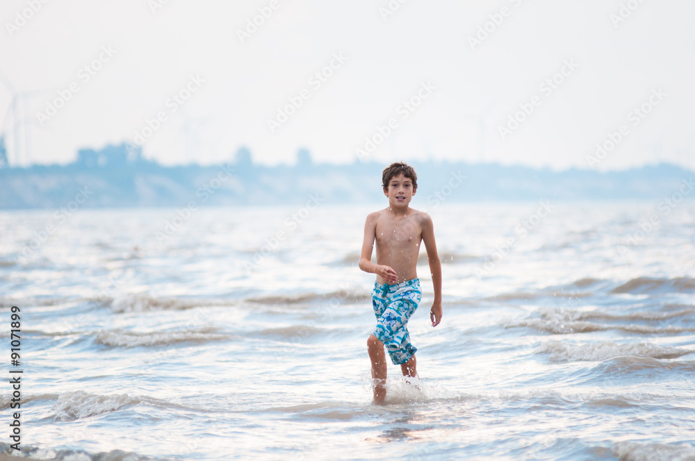 boy playing in the water at the shore of lake Erie boy playing in the water at the shore of lake Erie