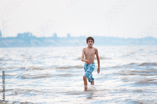 boy playing in the water at the shore of lake Erie