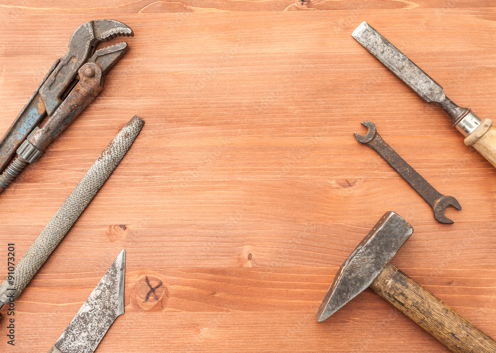 old rusty construction instruments on the wooden background old rusty construction instruments on the wooden background