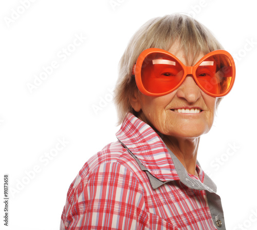 Senior happy woman wearing big sunglasses doing funky action