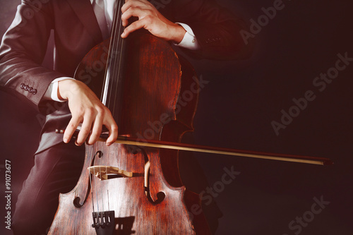 Obraz na płótnie Man playing on cello on dark background
