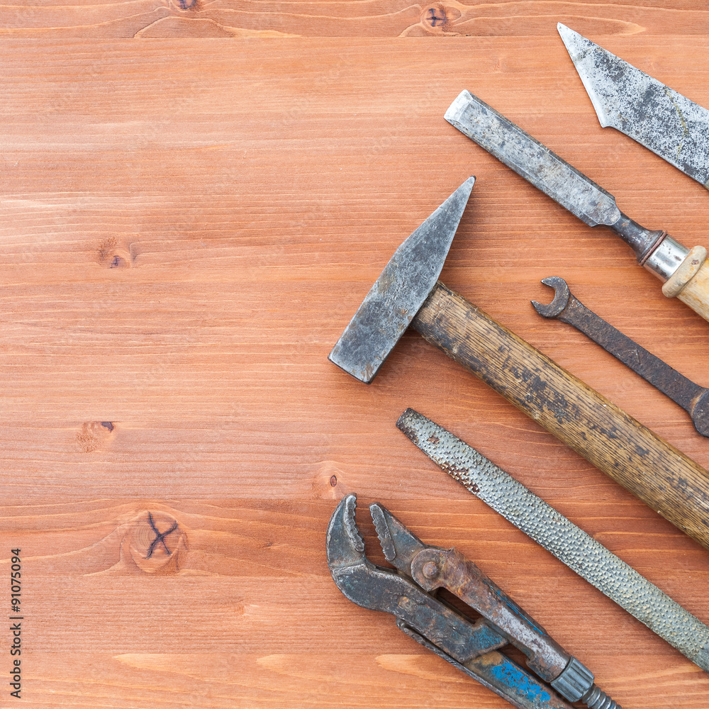 old rusty construction instruments on the wooden background old rusty construction instruments on the wooden background