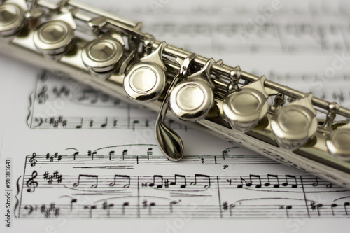 Photo Close up flute on flute sheet music background