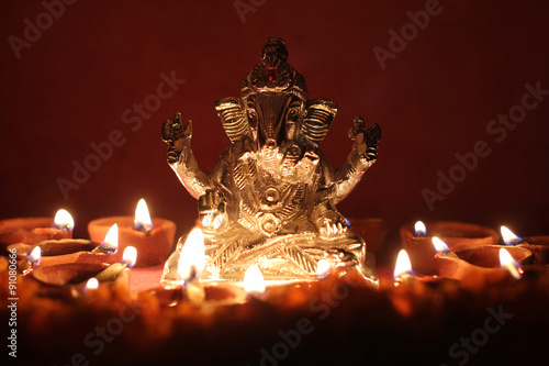 Ganesh idol surrounding with oil lamp, festival season